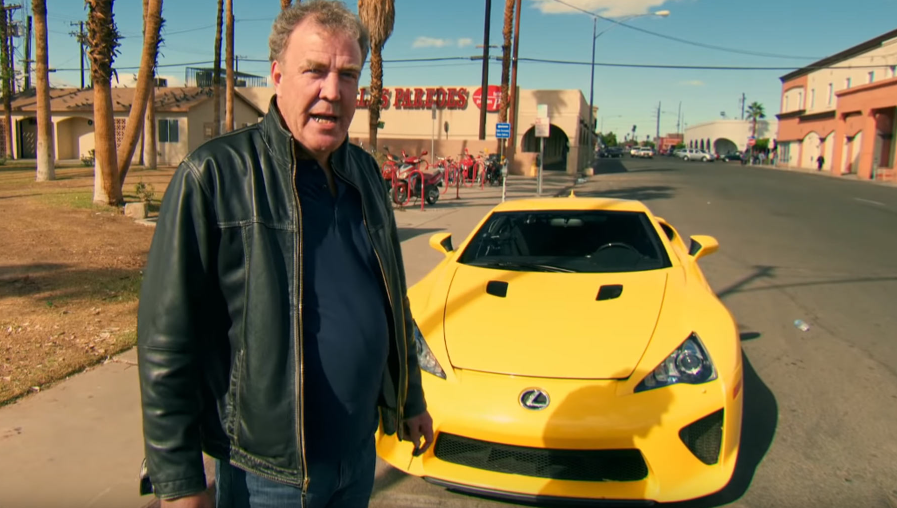 Jeremy Clarkson standing beside a yellow Lexus LFA